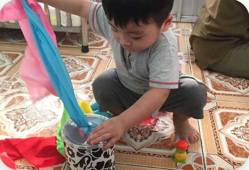 A child playing with colourful scarves during therapy